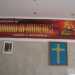 Una parete allestita con lo striscione di Dianetics, la foto di L. Ron Hubbard e la croce a otto punte simbolo di Scientology 